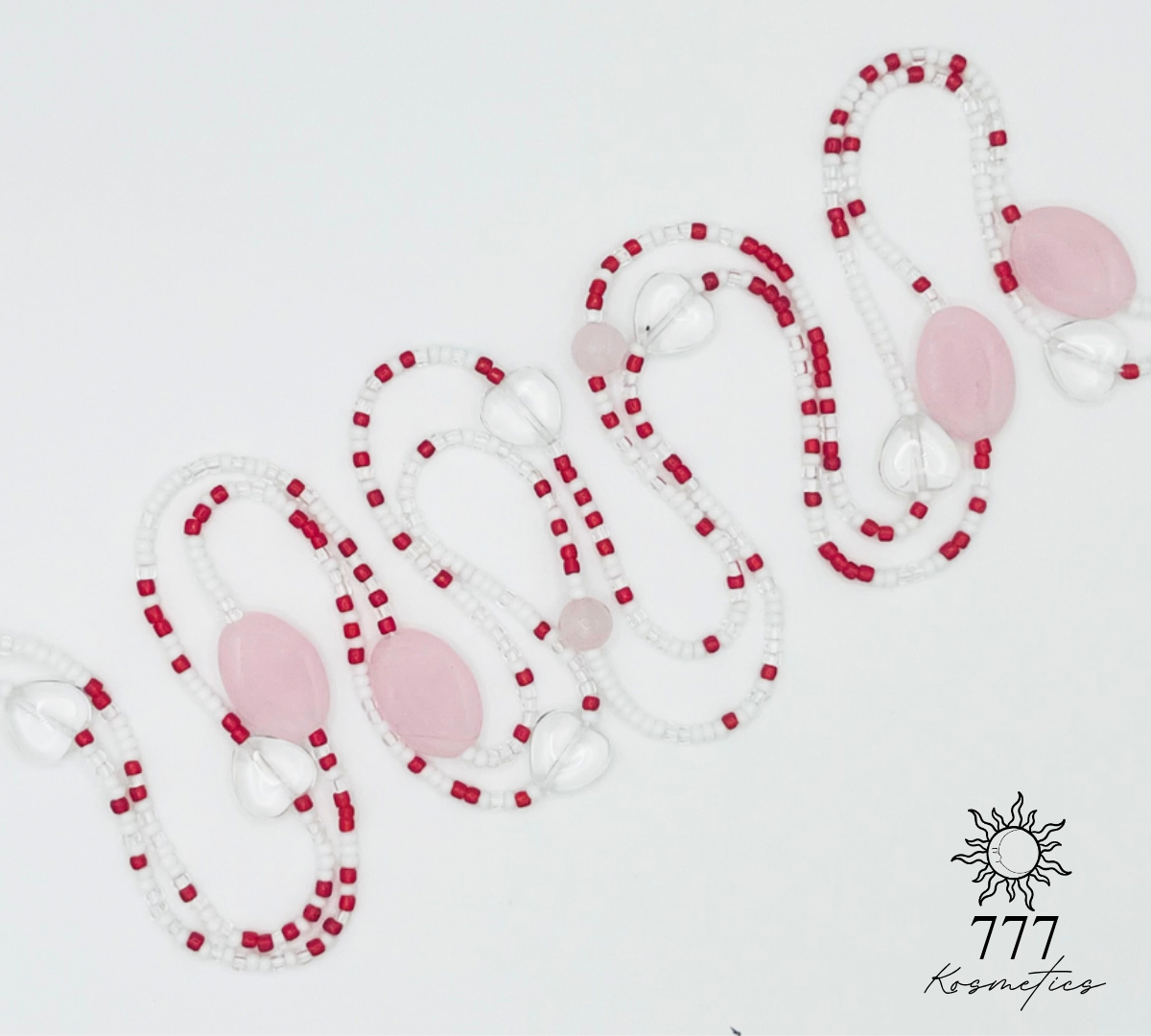 Waist beads that have red, white, and clear seed beads. Along with pink oval beads, genuine rose quartz gemstones, and clear heart beads. 
